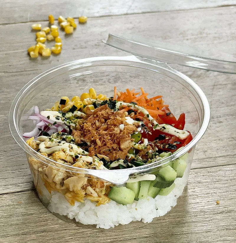 Poké bowl met rijst, groenten, kip en krokante uitjes